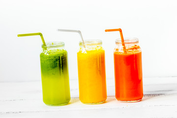 Fresh detox juices glass in row bottles on white background