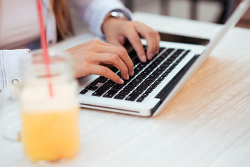 Close-up image of female person using laptop.