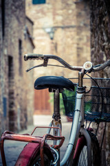 Fototapeta na wymiar Red old bicycle in a little alley of a medieval village