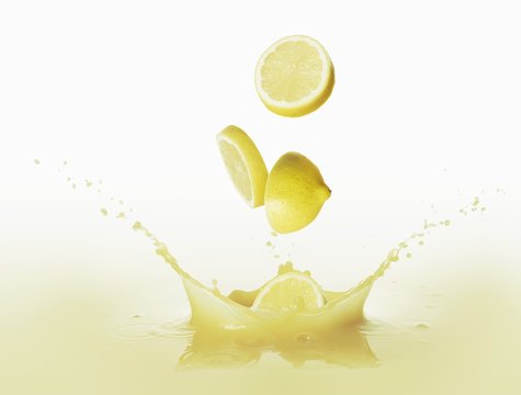 Lemons falling into lemon juice