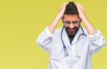 Adult hispanic doctor man over isolated background suffering from headache desperate and stressed because pain and migraine. Hands on head.