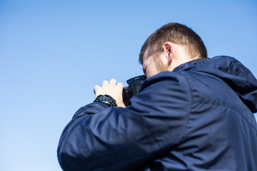 Nature photographer with digital camera on top of the mountain