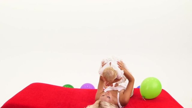 Woman playing with baby girl on floor