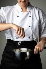 chef woman sprinkle salt cooking prepare food seasoning on grey background