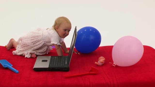 Baby girl playing with laptop