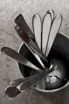 A metal cup with spoons