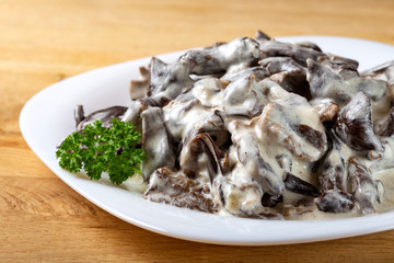 Stew made from brown mushrooms, sour cream and herbs