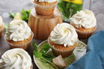 Sweet cupcakes with mint on table