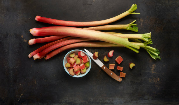 Overhead view of rhubarb stems and chopped rhubarb in bowl with knife