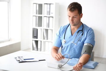 Male doctor measuring his blood pressure in hospital