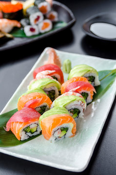 Japanese platter of rainbow rolls maki, inside out seaweed and rice roll filled with cucumber, mayonnaise, avocado, crub stick topped with fresh salmon, tuna, avocado and prawn