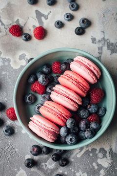Overhead view of macarons with berries in bowl
