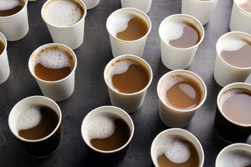 Many plastic cups with tasty aromatic coffee on table