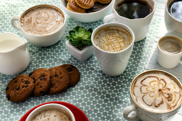 Many cups with tasty aromatic coffee on table