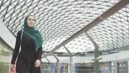 Pretty muslim woman in a hijab with a backpack goes to the store,slow mo