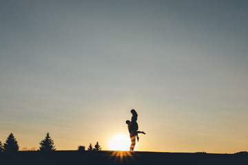 The guy picked up the girl in his arms at sunset
