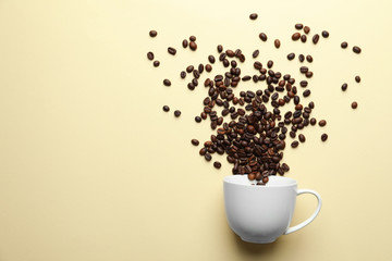 Composition with cup and coffee beans on color background