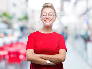 Young blonde woman wearing glasses over isolated background happy face smiling with crossed arms looking at the camera. Positive person.