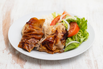 roasted pork with boiled rice and salad on white plate