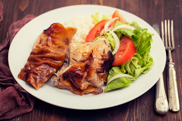 roasted pork with boiled rice and salad on white plate