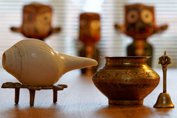 Conch shell and bell with brass water pot and the blurry background Hindu deity Lord Jagannath