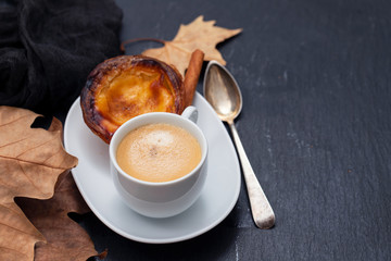 a cup of coffee with typical portuguese egg tart