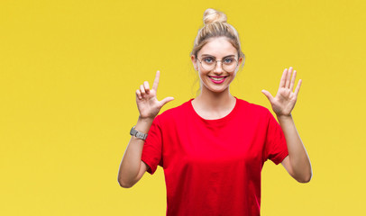 Young beautiful blonde woman wearing red t-shirt and glasses over isolated background showing and pointing up with fingers number seven while smiling confident and happy.