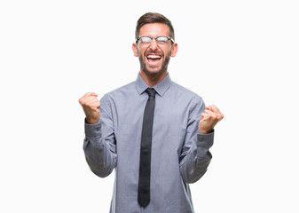 Young handsome business man over isolated background very happy and excited doing winner gesture with arms raised, smiling and screaming for success. Celebration concept.