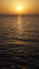 Sunset over Pacific Carribean beach showing dramatic red and yellow sky as sun sets 