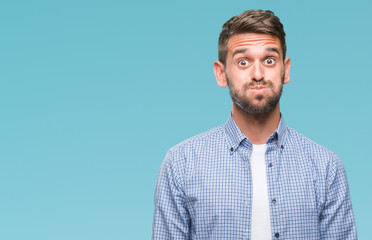 Young handsome man wearing white t-shirt over isolated background puffing cheeks with funny face. Mouth inflated with air, crazy expression.