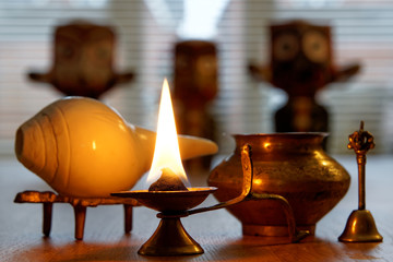 Burning the ghee candle with Puja set and Hindu deity Lord Jagannath in the blurry background