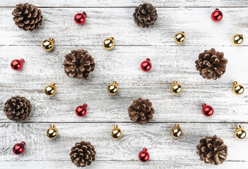 Old wooden Christmas background. Red and gold baubles and cones. Top view.