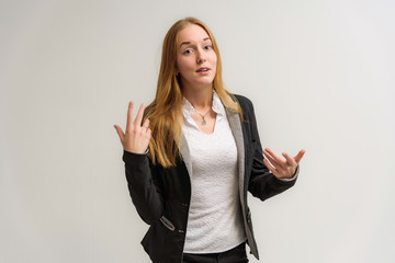 Studio portrait on the camera of a smiling beautiful girl with long hair talking on a white background with emotions.