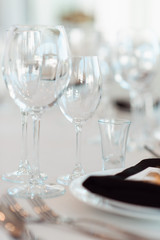 Sparkling glassware stands on table prepared for wedding. Wedding decor, interior. Festive. Banquet table