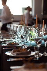 Sparkling glassware stands on table prepared for wedding. Wedding decor, interior. Festive. Banquet table.