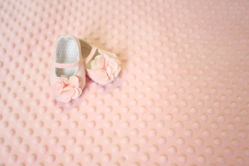 Baby newborn pink background, vintage newborn shoes for baptism on soft texture background , blank space for message