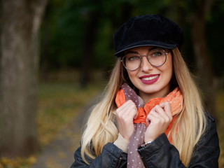 Portrait of a frozen beautiful stylish young blonde in glasses and a cap with makeup