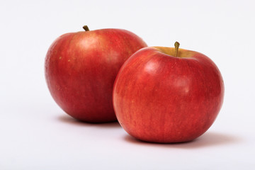 Two ripe red apples on a white background