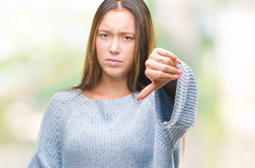 Young beautiful caucasian woman wearing winter sweater over isolated background looking unhappy and angry showing rejection and negative with thumbs down gesture. Bad expression.