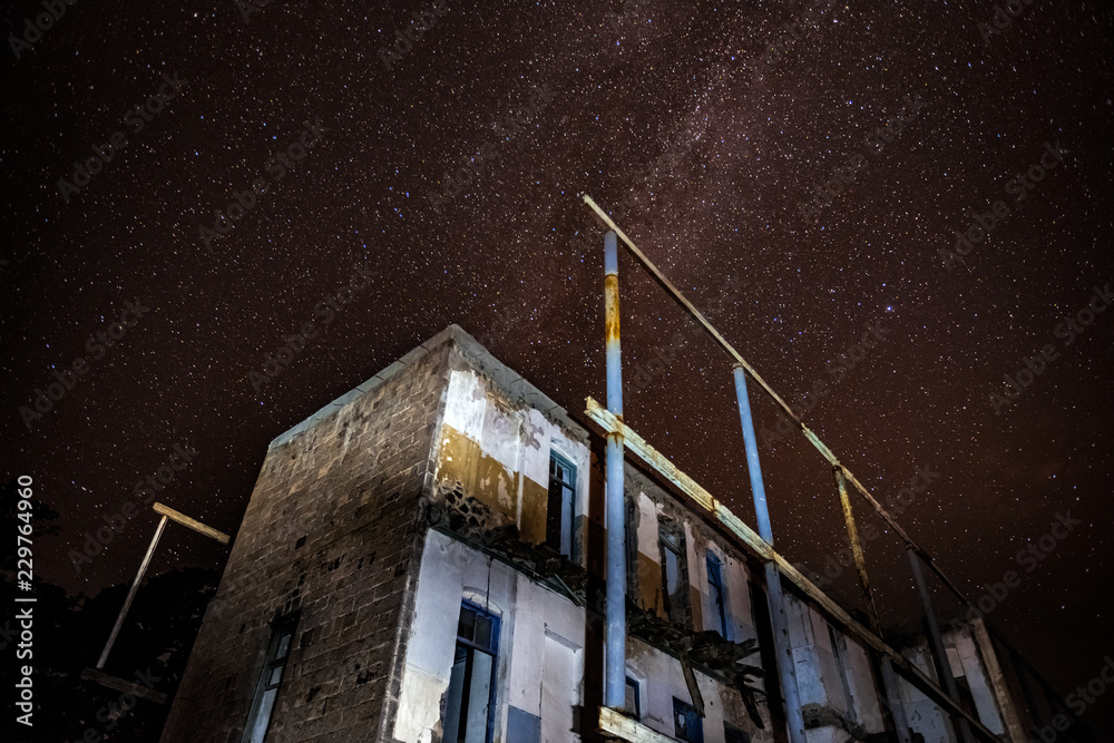 Wall mural night sky and the milky way over the old abandoned house