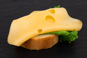 open healthy sandwich with cheese and lettuce on dark background