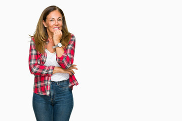 Middle age adult woman wearing casual shirt over isolated background looking stressed and nervous with hands on mouth biting nails. Anxiety problem.