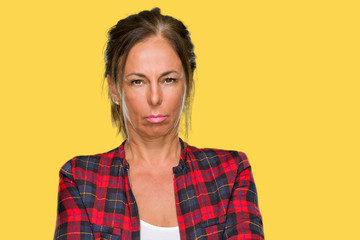 Middle age adult woman wearing casual jacket over isolated background skeptic and nervous, disapproving expression on face with crossed arms. Negative person.