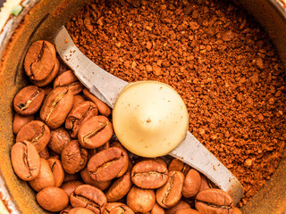 Macro photo of freshly ground coffee in electric coffee grinder. In one half whole grains of coffee, and in the other half ground.