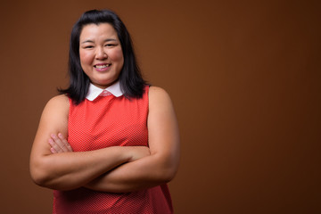 Obraz premium Happy beautiful overweight Asian woman smiling with arms crossed