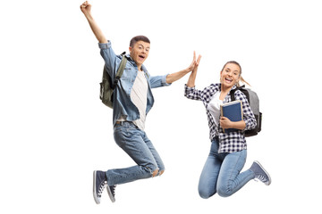 Two overjoyed teenage students in mid-air high-fiving each other