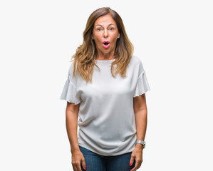 Obraz premium Middle age senior hispanic woman over isolated background afraid and shocked with surprise expression, fear and excited face.