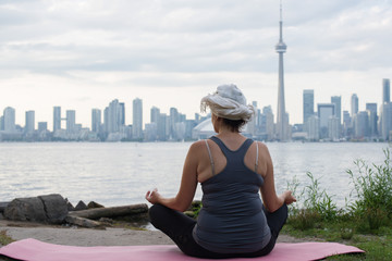 Middle aged woman practicing yoga at the front of Toronto