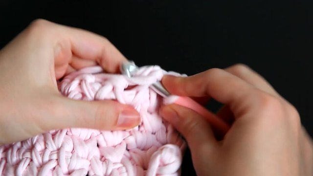 Crochet with pink yarn - spaghetti knitting technology, leisure and handmade