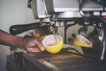 Closeup of Barista making  fresh espresso with a classic Italian coffee machinevintage vintage color.selective focus - obrazy, fototapety, plakaty